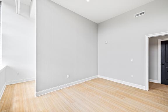A room with wooden flooring and white walls.