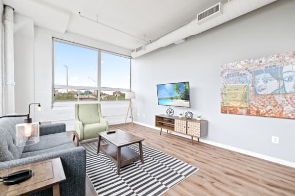 a living room with white walls and hardwood floors