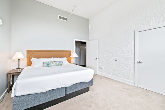 a bedroom with a large bed and a door to a bathroom