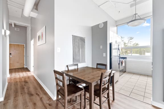 a dining area with a wooden table and chairs and a large window with a view of the