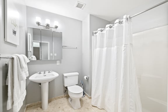 a bathroom with a white shower curtain and a white toilet