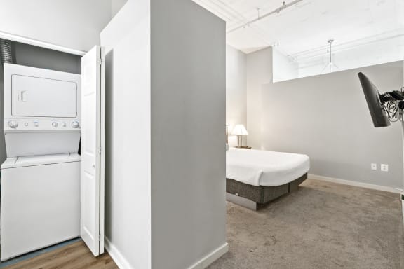 a bedroom with a bed and a washer and dryer