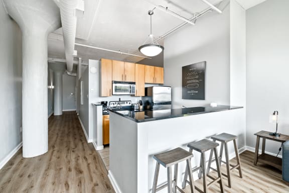 a kitchen with a breakfast bar and stools in a 555 waverly unit