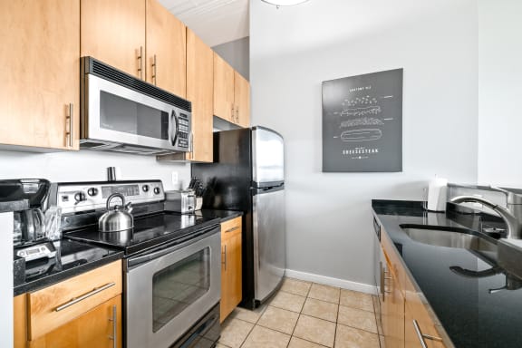 a kitchen with black countertops and stainless steel appliances