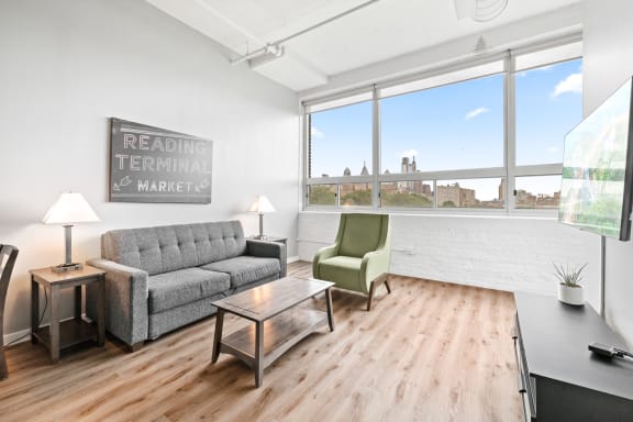 a living room with a couch chair coffee table and a large window