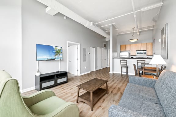 a living room with a couch a chair a coffee table and a flat screen tv