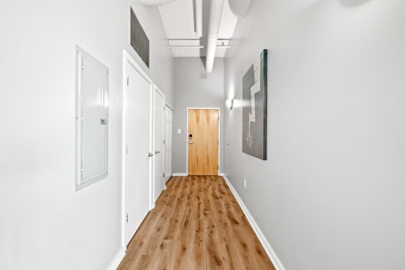 a long hallway with white walls and wood floors
