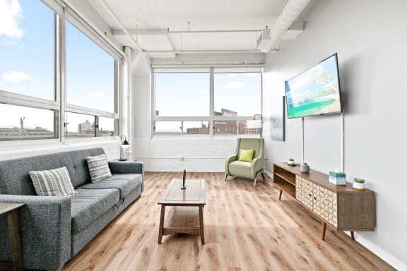 a living room with wood floors and large windows