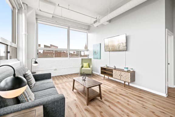 a living room with a large window and hardwood floors