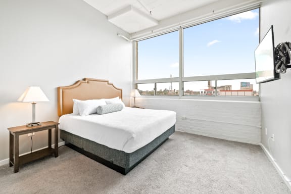 a bedroom with a bed and a large window