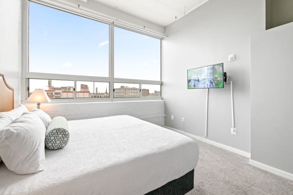 a bedroom with a large window and a large bed