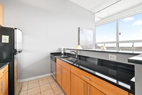 a kitchen with black countertops and a large window