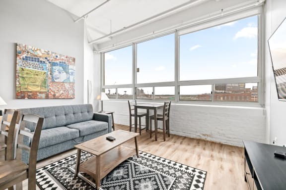 a living area with a couch table and chairs and a large window with a view of a