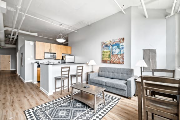 a living room with a couch coffee table and a kitchen in the background