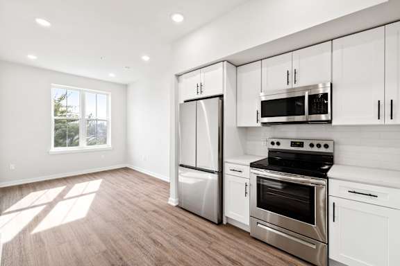 A kitchen with white cabinets and stainless steel appliances.