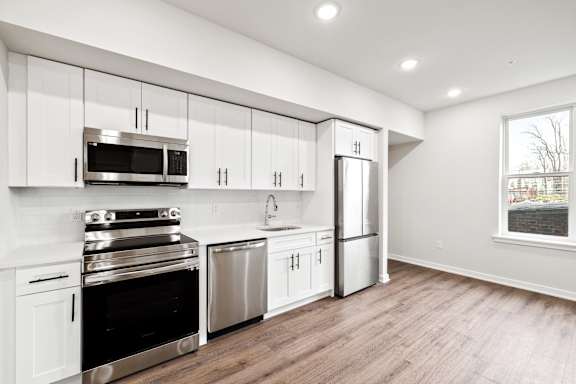 A kitchen with white cabinets and stainless steel appliances.