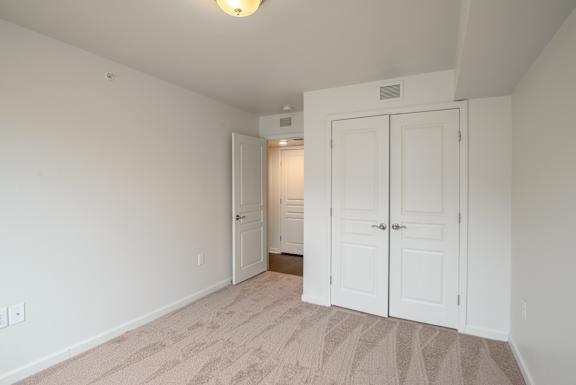 A room with white walls and a carpeted floor with two white doors. at Timberland Park Apartments, Charlottesville, VA