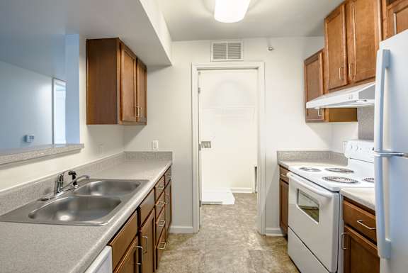 A kitchen with a white door and a white stove. at Timberland Park Apartments, Charlottesville, Virginia