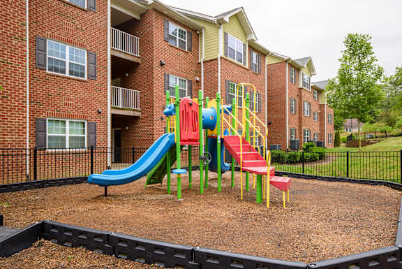 A playground with a blue slide and red and yellow stairs. at Timberland Park Apartments, Charlottesville, VA, 22903