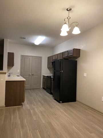 Kitchen with black appliances and wooden cabinets at Etiwan Place, SC 29445