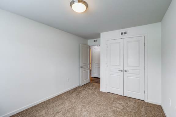 A white door is in a room with carpeting at Ada Park Apartments, Virginia