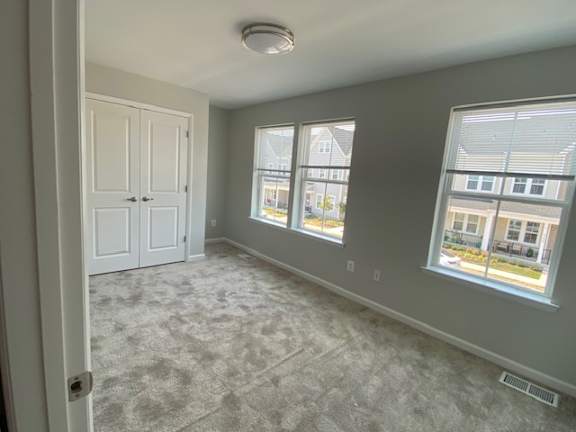an empty room with two windows and a door