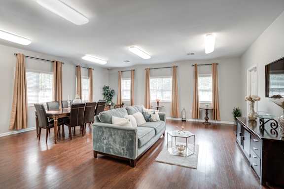 A living room with a grey couch and wooden floors.