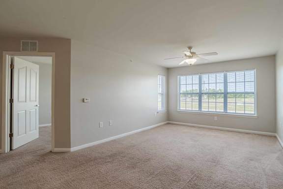A room with a ceiling fan and a door at Carriage Hills, Lumberton, NC