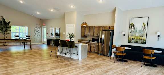 A kitchen with a refrigerator, sink, and bar area.