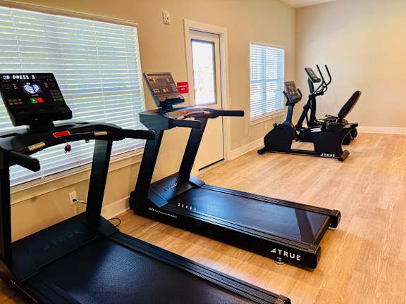 A room with a treadmill and a stationary bike.