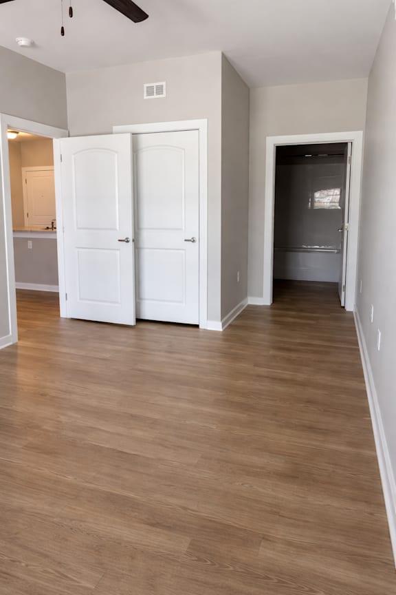 A room with two white doors and a ceiling fan.