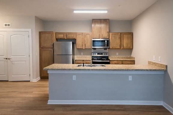 A kitchen with a granite countertop and wooden cabinets.