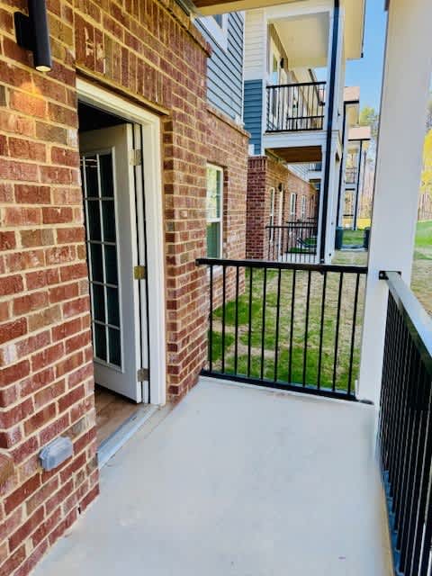 A brick building with a white door and a black fence.