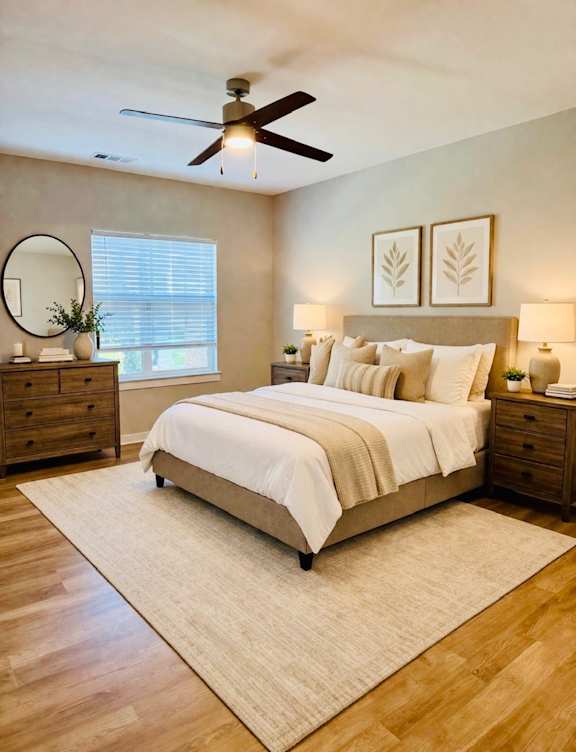 A bedroom with a bed, dresser, and ceiling fan.