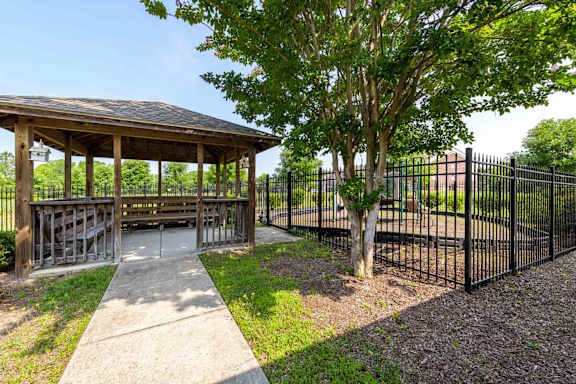 A gazebo is surrounded by a black fence and a tree at Granite Falls Apartments, North Carolina