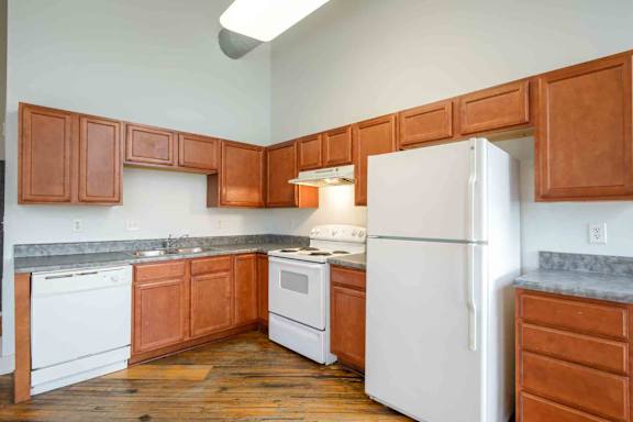Kitchen with wooden cabinets at Kemper Lofts Apartments, Lynchburg