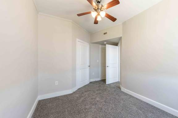 A room with a ceiling fan and carpeted floor.at Kinston Hotel Apartments, North Carolina