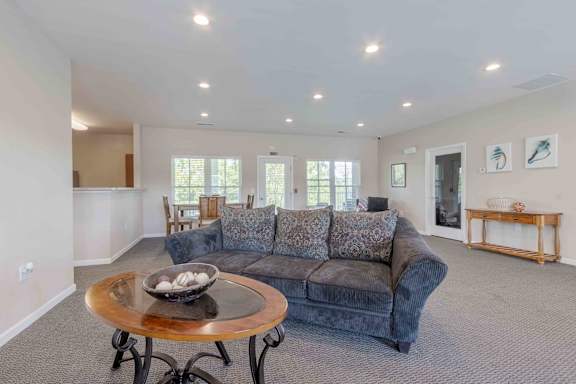 A living room with a grey couch and a wooden coffee table.