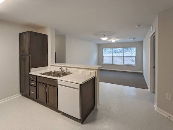 A kitchen with white countertops and brown cabinets. at Bickerstaff Crossing Apartments, Virginia