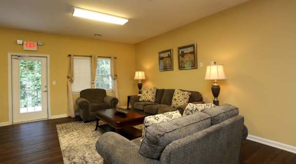 A living room with a grey couch, a brown coffee table, and a lamp at Robinson Park Apartments, Harrisonburg 22801