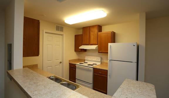 A kitchen with a white refrigerator, white stove, and white countertop at Robinson Park Apartments, Harrisonburg, VA