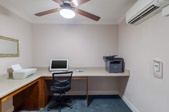 A room with a desk, chair, and a ceiling fan. at Snowden Senior Apartments, Virginia