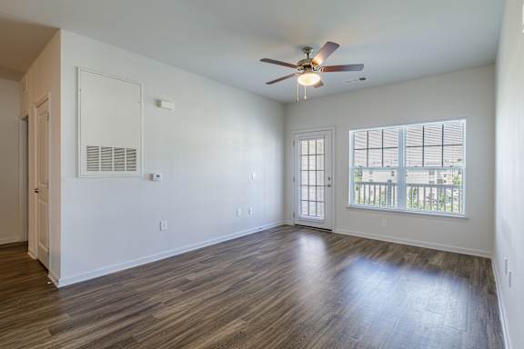 A room with a ceiling fan and a window with blinds.