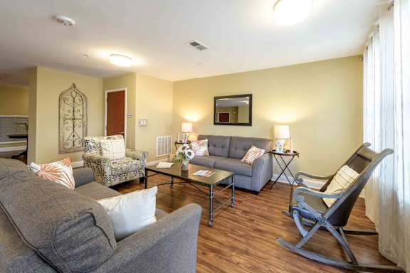 A living room with a grey couch, a chair, and a coffee table. at The Grande at Granite Falls LLC Apartments, North Carolina, 27571