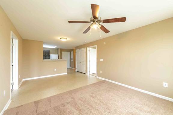 A spacious room with a ceiling fan and carpeted floor. at The Grande at Granite Falls LLC Apartments, Rolesville