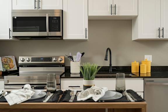 A modern kitchen with a stove, microwave, and oven.