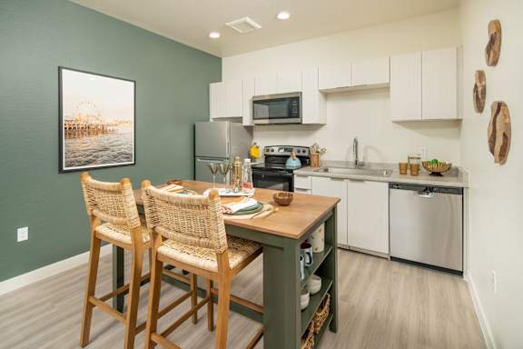 A kitchen with green walls and a wooden table.