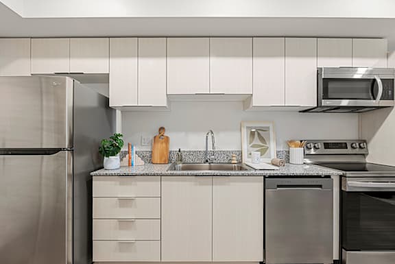 A modern kitchen with stainless steel appliances and white cabinets.