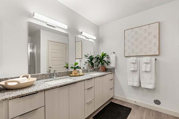 A bathroom with a sink, mirror, and towel rack.