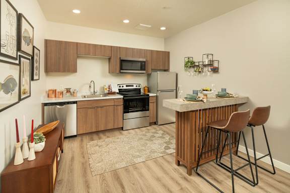 A modern kitchen with a wooden island and bar stools.